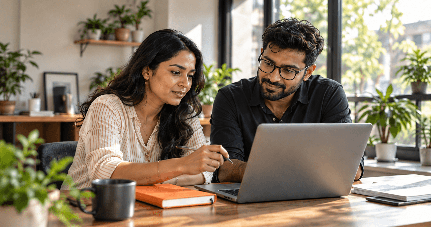 A business owner and digital consultant exploring ideas together at a laptop